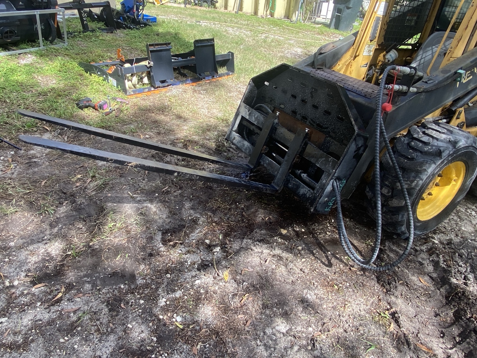 Attachment mounted on skid steer · Actual item photo